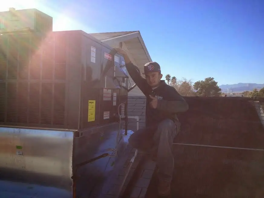 HVAC technician performing Heat Pump Repair on a rooftop unit in Eugene